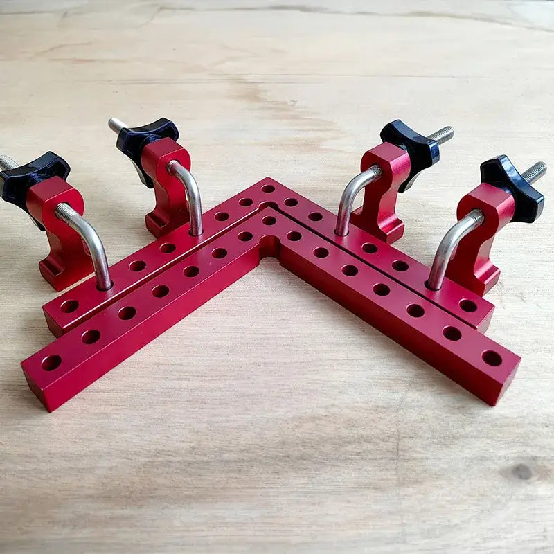 Red metal angle clamp with adjustable screw mechanisms for precise woodworking joints