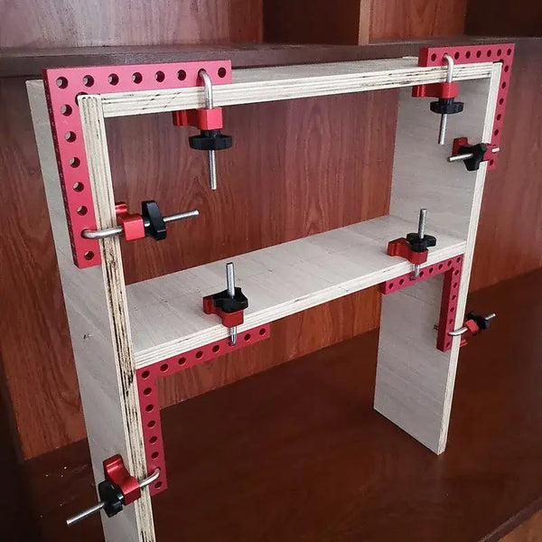 Wooden frame with red metal brackets and clamps for a 90 degree angle clamp