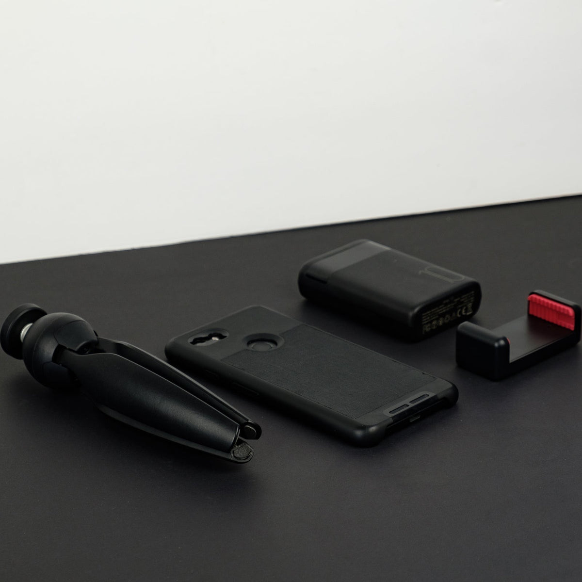 Monochromatic flat lay of mobile phone accessories