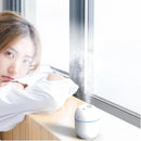 Young woman with short hair near a window, showcasing BALASHOV Mini Ultrasonic Air Humidifier