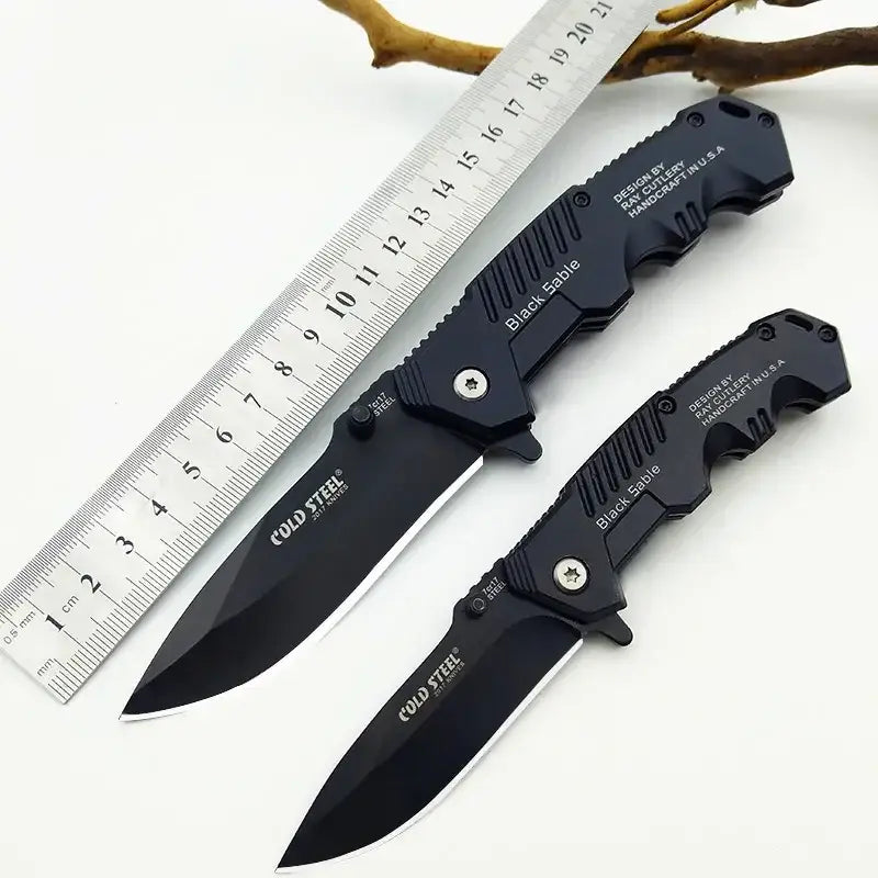 Two folding tactical knives from IROVNE DIY Supplies featuring black handles and blades