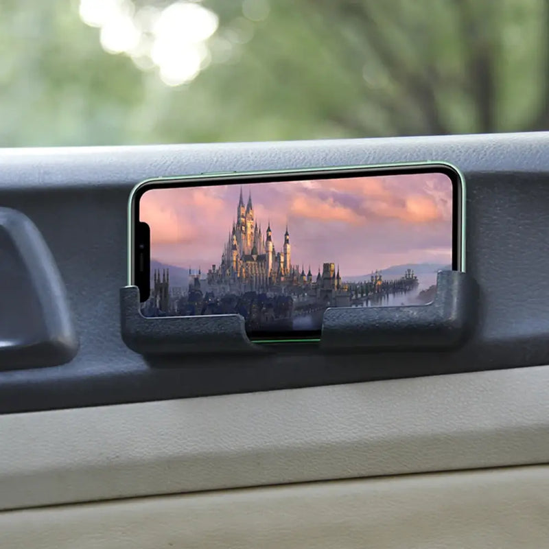 Smartphone in car phone mount showcases fantasy castle at sunset, highlighting applicable mobile use