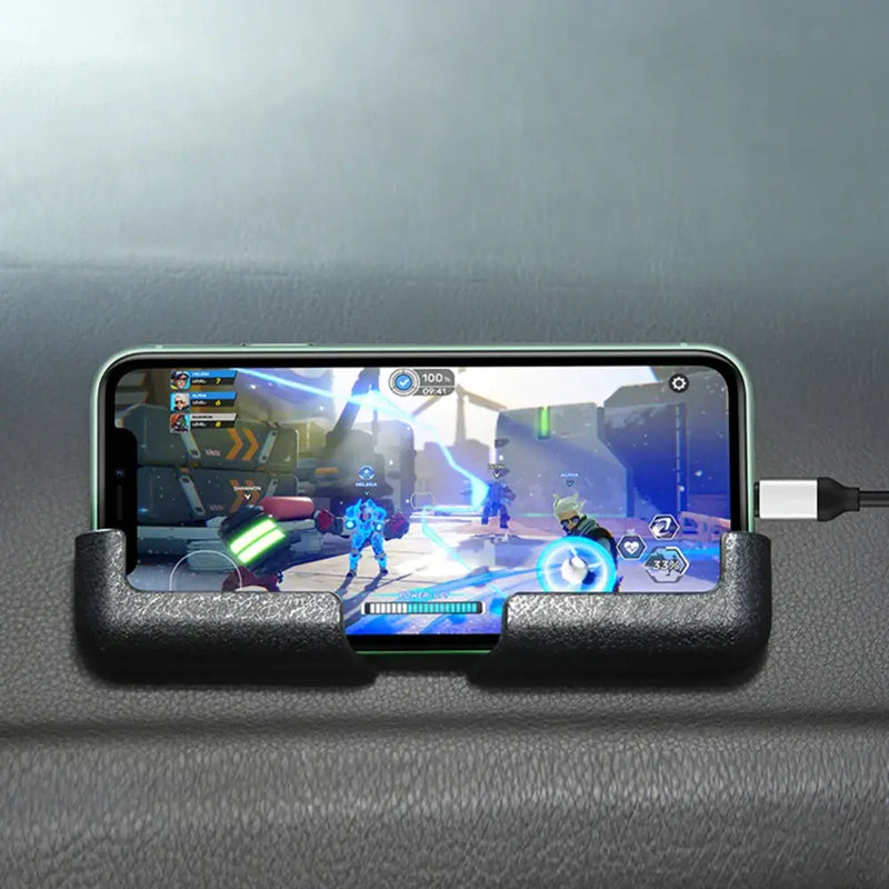 Smartphone in car phone mount displays vibrant video game scene while charging