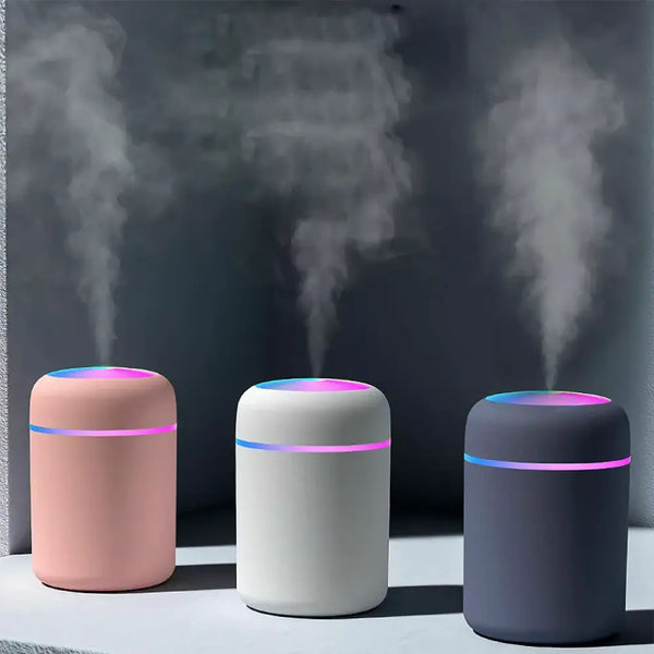 Three cylindrical essential oil diffusers in pink, white, and dark gray for Mainland China