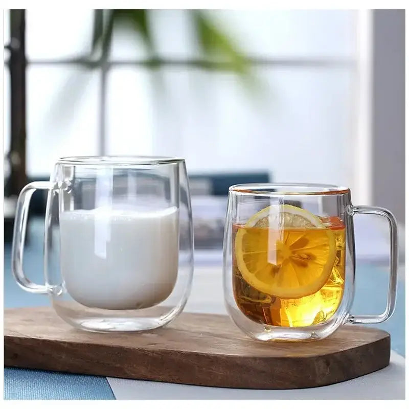 Transparent double wall glass mugs with milk and tea with lemon in a stylish set