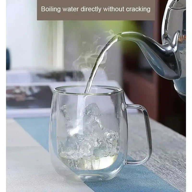 Boiling water being poured into a transparent double wall glass cup from a kettle