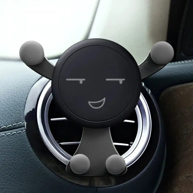 Smiling cartoon-faced car phone holder mounted in air vent for secure access