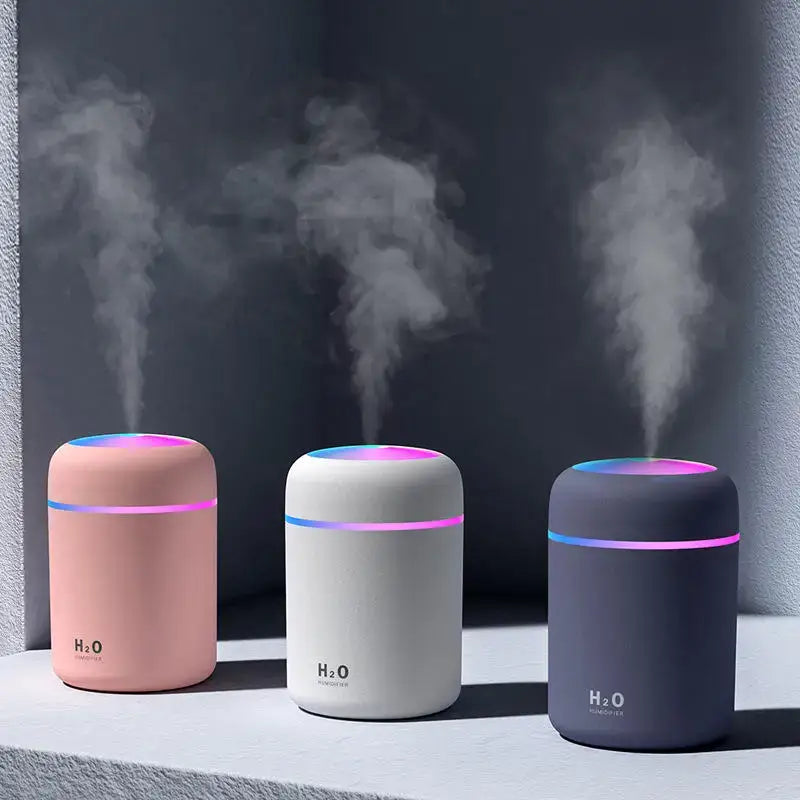 Three colorful Xiaomi 300ml H2O Air Humidifiers emitting steam in compact design