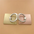 Two metallic finger ring holders in pastel yellow and pink on a rectangular plate